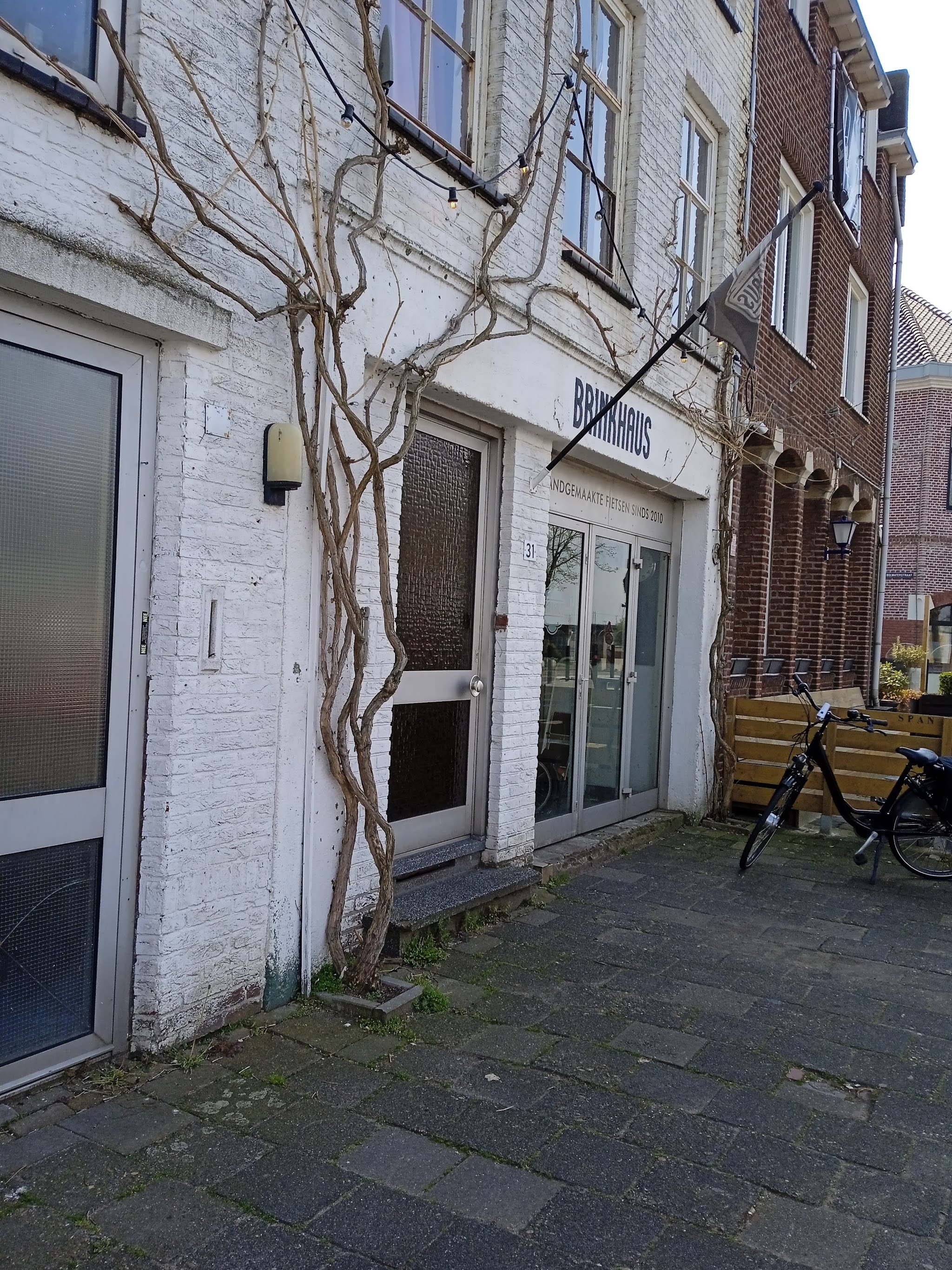 De ingang van BRINKHAUS aan de Maaskade, met de naam op de witte gevel